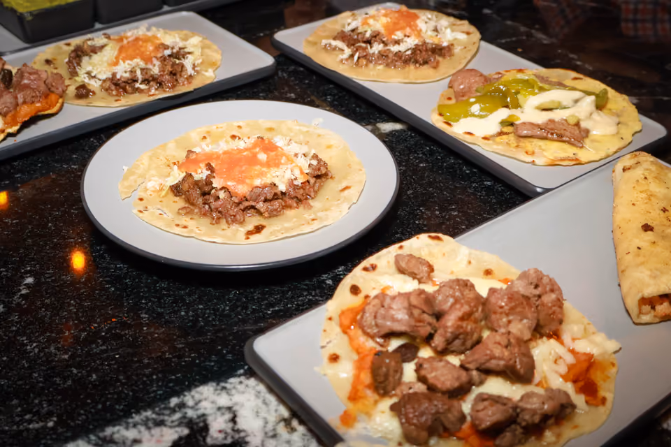 Mesa con varios platos de tacos listos para compartir